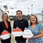 GOOD TO GO: A Wing Australia drone takes off behind Cr Nicole Jonic, Simon Rossi and Mayor Teresa Harding as it flies out to deliver one of the first food packs from the Orion Springfield drone nest.