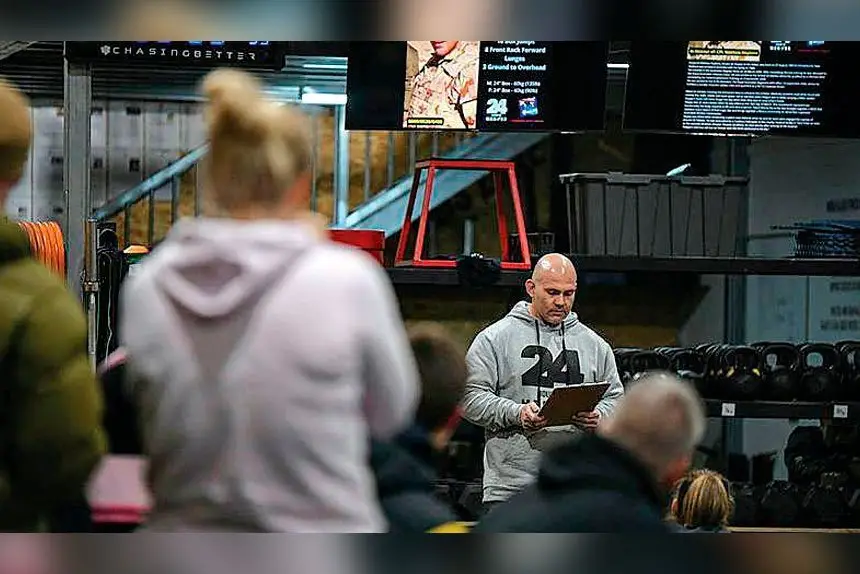 Warrant Officer Class 2 Beau Thomas reads the biography of a fallen soldier before the workout begins at the fundraiser for Wounded Heroes. Photo: TrewBella Photography
