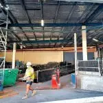 WORK SLOWS: A lone tradesman picks up rubbish at the Venue building last week.