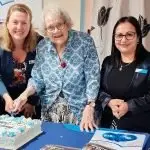 CUTTING THE CAKE: Mayor Teresa Harding with BlueCare resident Joyce Woodhead who, at 98, is the centre’s oldest resident. With them is service manager Amrita Thapaliya.