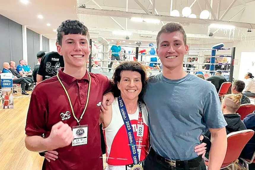 MUM PACKS A PUNCH: Kim Bennett celebrates her title win with her sons, Joe and Jeff