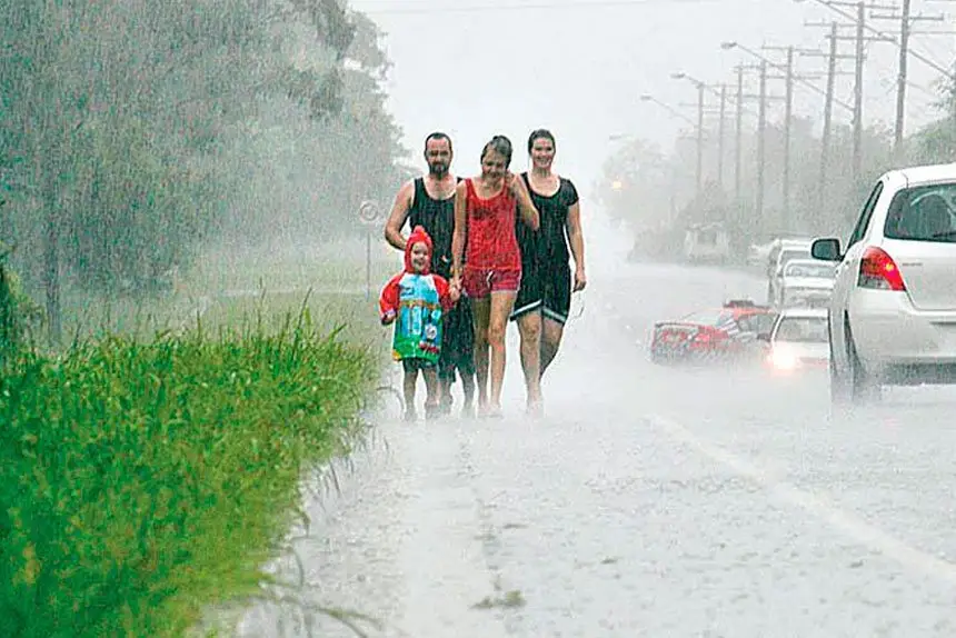 DRENCHED:  A family evacuate their home as the floodwater rises.