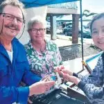 Local gem dealers, Maurie and Toni Newbery show Heather Hu one of their gems.