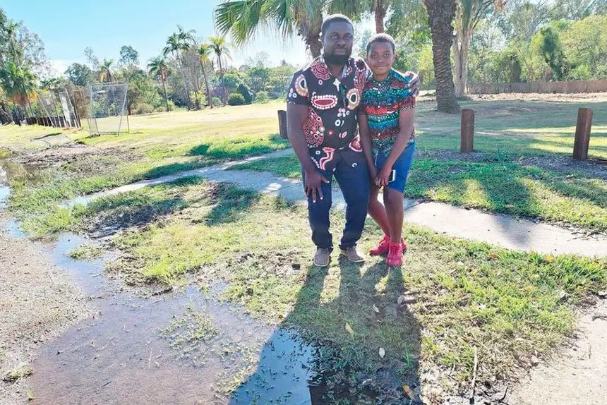 TIME TO SELL: Former Goodna flood home owner, Chris Onyeajum, is advising owners to grab the buy-back offer before it goes. He is pictured with his son, Nnamdi.