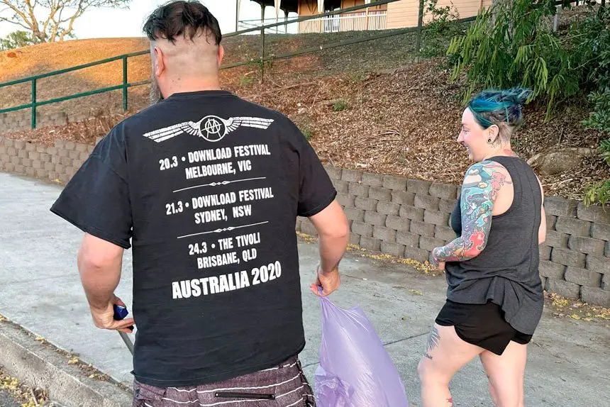 Chloe and Nick collect trash on their evening walk.