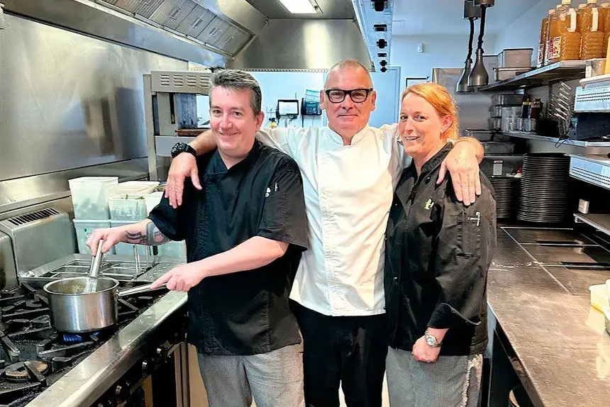 TASTY TEAM: Neil Smith (centre) cooks up magnificent munchies with members of his catering crew Kieran Smith and Chrissie Voll, with whom he shares credit for his success.