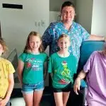 Luke with his three daughters and a patient during the EWE program.