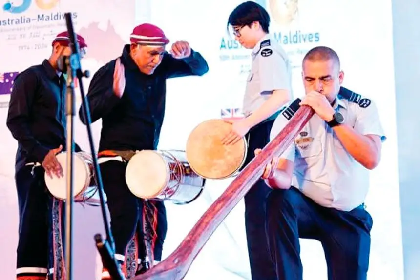 Traditional Bodu Beru drummers, including RAAF Band drummer Corporal Naomi Tan, accompany RAAF didgeridoo player Flight Lieutenant James Evans.