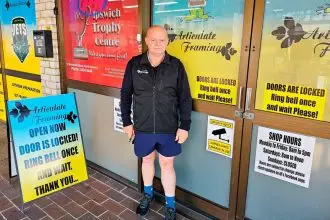 The locked door policy is highlighted on a sign outside of the shop.