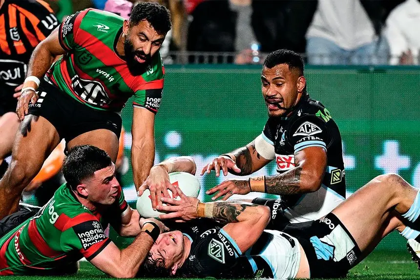 Nicho Hynes of the Sharks is held up by Lewis Dodd and denied a try against the Rabittohs. PHOTO AAP