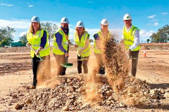 Mayor Teresa Harding, left, turns the sod on the Officeworks site at Redbank Motorway Estate with representatives from Officeworks and Goodman Group.