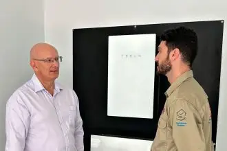 BRIGHT SUCCESS: Federal Member for Blair Shayne Neumann chats with Fallon Solutions technician Jade as he installs a solar battery.