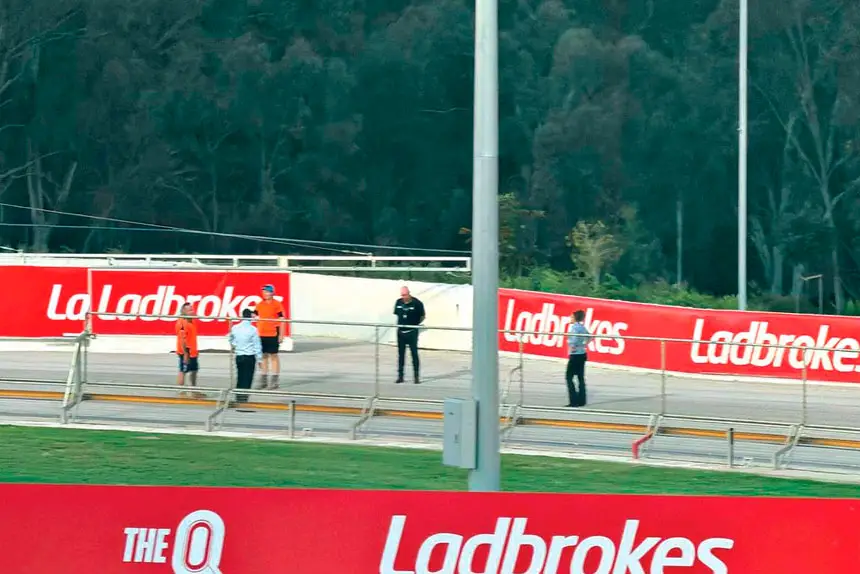 CONFUSION REIGNS: Track officials and workers stand around outside the catching pen before the abandonment of the meeting.