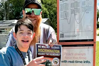 TAKING ACTION: Rhyley Schultz is placing posters at city bus stops.