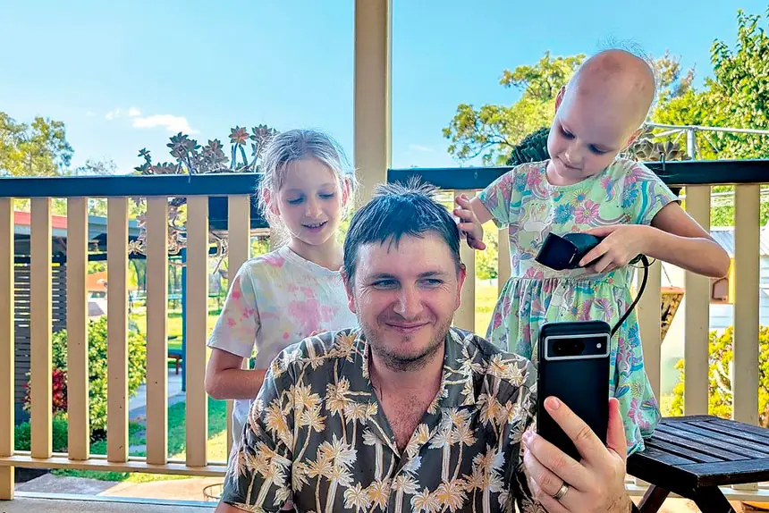 SISTER ACT: Abby and big sister Emily enjoy giving their father Rick a hairstyle to match Abby’s.