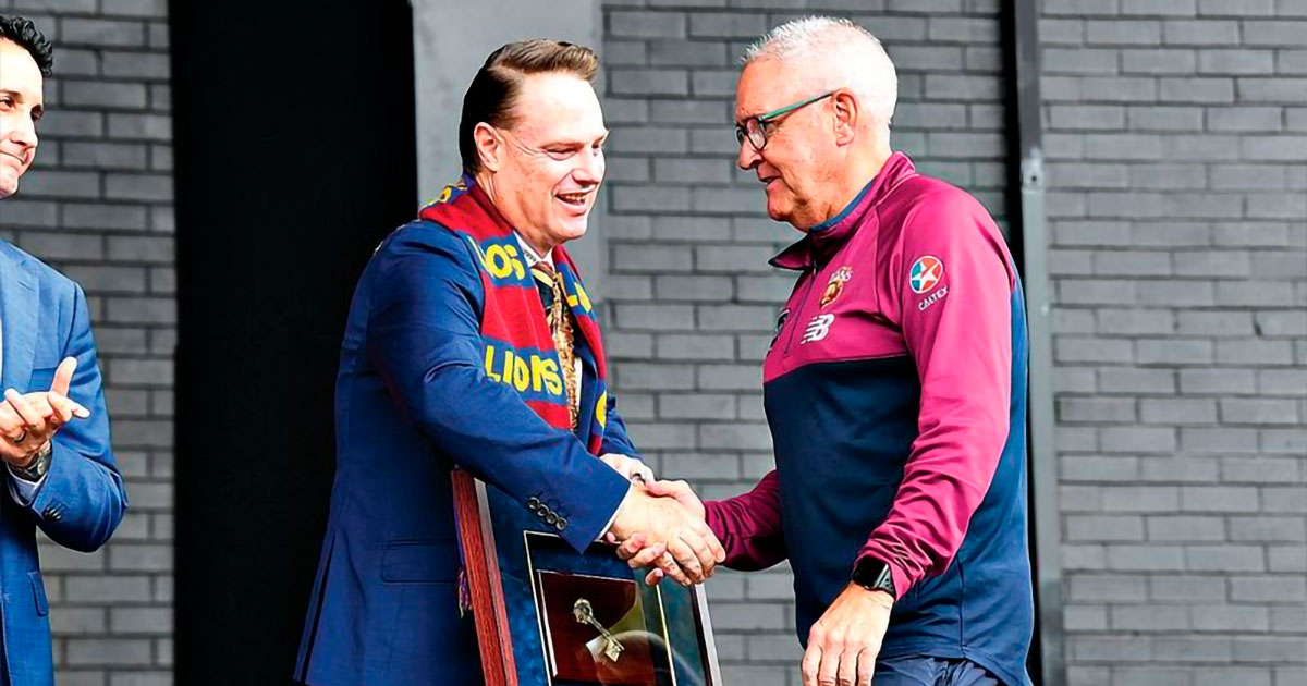 Brisbane Lord Mayor Adrian Schrinner gives Lions coach Chris Fagan the Keys to the City after his team secured the 2026 AFL Grand Final. (AAP Image/Jono Searle)
